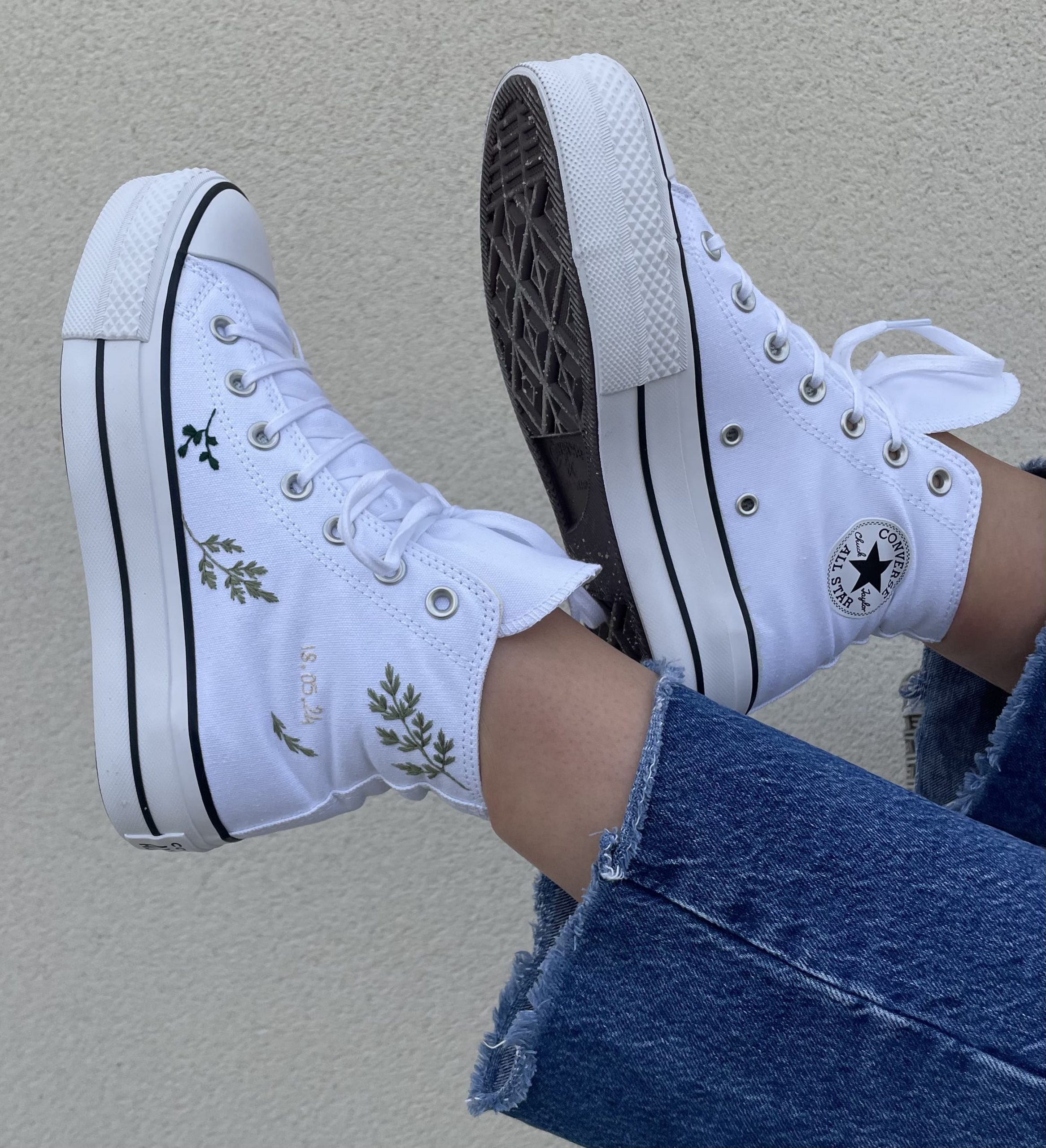 Une paire de baskets personnalisée couleur blanche avec du feuillage vert