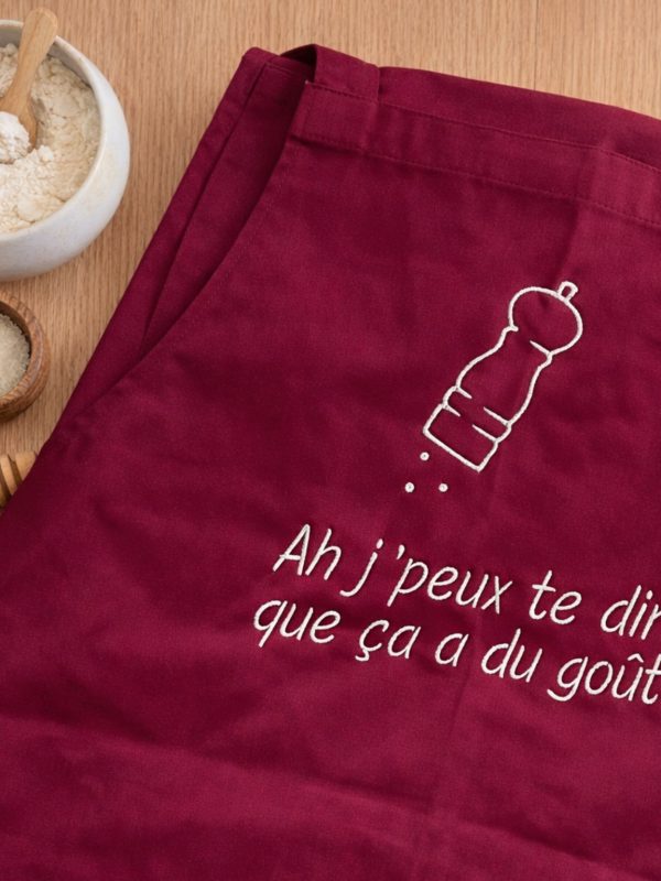 Tablier de Cuisine Brodé sur un plan de travail avec farine et miel