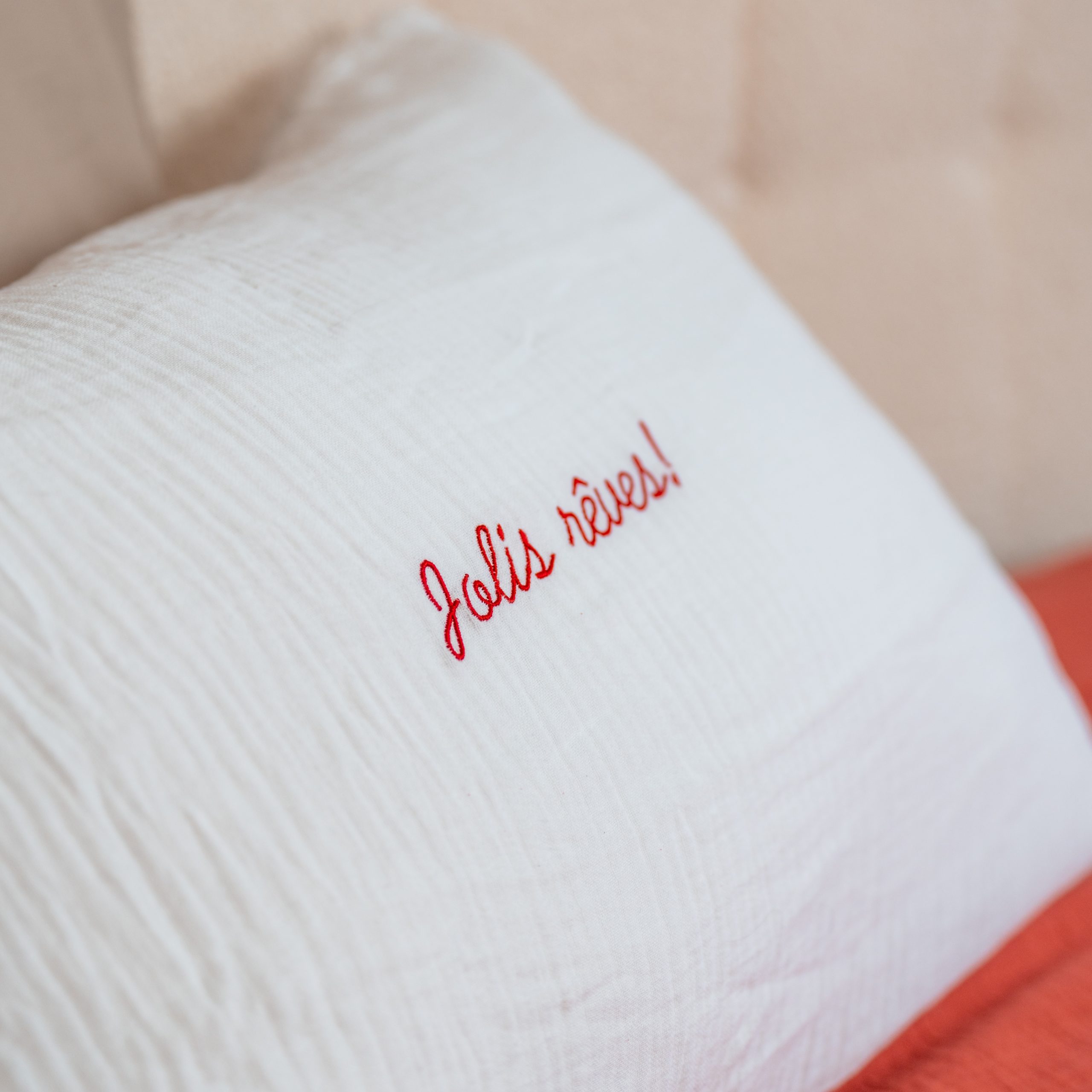 taie d'oreiller en gaze de coton avec une broderie "Jolis rêves" couleur rouge