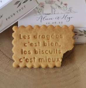 Un biscuit sablé personnalisé, avec écrit "Les dragées c'est bien, les biscuits c'est mieux"