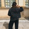 Femme de dos, portant une veste en jean avec de la broderie motif cerise