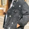 Zoom sur une veste en jean broderie motif marguerite