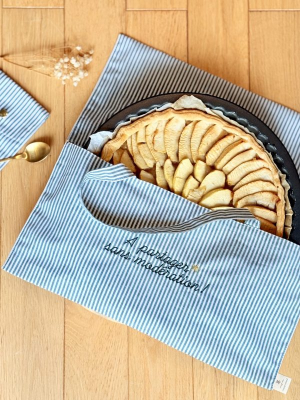 Sac à tarte personnalisé modèle rayures posé au sol avec une tarte aux pommes à l'intérieur